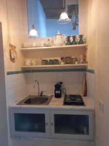 a small kitchen with a sink and a stove at Camere Urbevetus in Orvieto