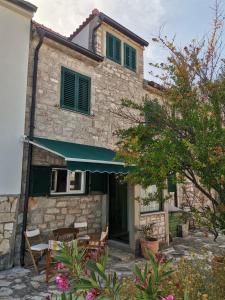 a building with a table and chairs in front of it at Charming Traditional Townhouse - Holiday Home Kata in Jezera