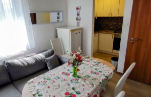 a dining room table with a vase of flowers on it at Clara apartman in Csopak