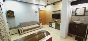a bathroom with a couch and a sink and a tv at Alibaug Castle Villa in Nagaon