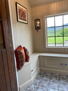 um quarto com um banco e uma janela em Quirky Highland Cottage with Stunning Views em Wester Fearn