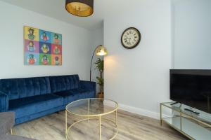 a living room with a blue couch and a clock at Heath House in Burton upon Trent
