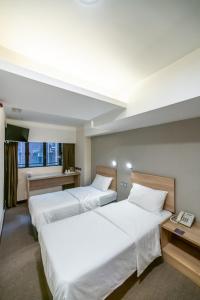 a hotel room with two beds and a phone at metacity living in Hong Kong