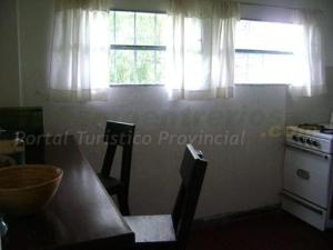 a kitchen with a wooden table and two windows at La Vieja Calera in Victoria