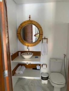 ein Badezimmer mit Waschbecken, Toilette und Spiegel in der Unterkunft Casa Branca BG in Barra Grande