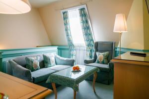 a living room with two chairs and a couch and a table at Hotel König von Ungarn in Vienna