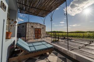 a room with a hammock and a view of a vineyard at Narbona Wine Lodge in Carmelo