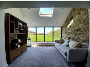 a living room with a couch and a stone wall at Coxgreen Old Schoolhouse in Sunderland