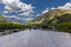 a balcony with a view of a river and mountains at GP Rooms in Stepantsminda