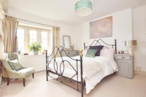 a bedroom with a bed and a chair at Quintessential Cottage near Bath, Grade 2 Listed. in Paulton