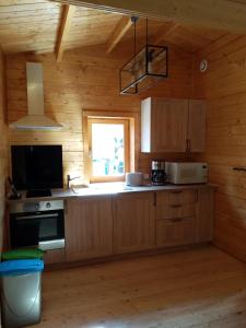 una cocina con armarios de madera y una ventana en chalet audruicquois, en Audruicq