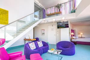 a living room with purple chairs and a staircase at Hotel König von Ungarn in Vienna