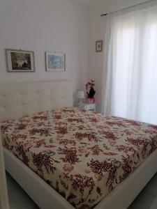 1 dormitorio con 1 cama con manta de flores en villa Eolo, en Lipari