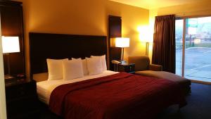 une chambre d'hôtel avec un lit, une chaise et une fenêtre dans l'établissement Cedars Inn, à Wenatchee