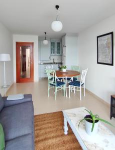 sala de estar y cocina con mesa y sillas en Casa Charo - Sardiñeiro, en Finisterre