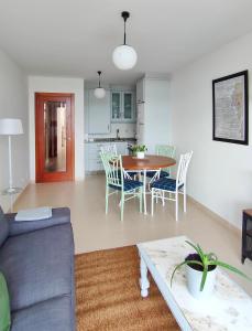 a living room and kitchen with a table and chairs at Casa Charo - Sardiñeiro in Fisterra