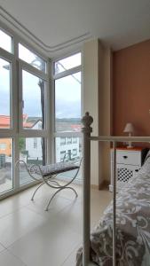 um quarto com uma cama e uma grande janela em Casa Charo - Sardiñeiro em Fisterra