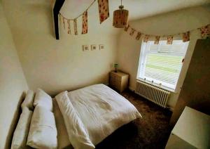 un dormitorio con una cama y una ventana en Coxgreen Old Schoolhouse, en Sunderland