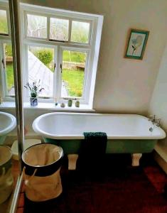 una bañera en un baño con ventana en Coxgreen Old Schoolhouse, en Sunderland