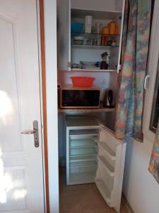 a kitchen with an open pantry with a microwave at Les ailes d'un reve in Vidauban
