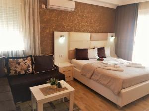 a bedroom with a bed and a couch at Apartmants Elisa in Ulcinj