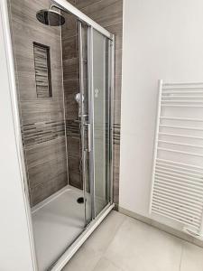 a shower with a glass door in a bathroom at Les Mouettes. Appart Honfleur 4 personnes vue pont de Normandie in Honfleur