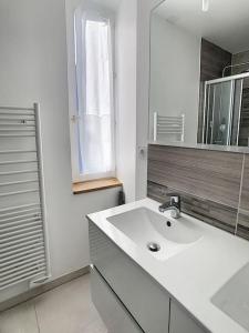 a white bathroom with a sink and a mirror at Les Mouettes. Appart Honfleur 4 personnes vue pont de Normandie in Honfleur