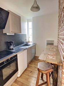 a kitchen with a counter and a wooden table at Les Mouettes. Appart Honfleur 4 personnes vue pont de Normandie in Honfleur