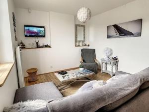 a living room with a couch and a chair at Les Mouettes. Appart Honfleur 4 personnes vue pont de Normandie in Honfleur