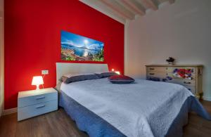 1 dormitorio con pared roja, cama y vestidor en Lecco Lake Apartments Villa Liberty, en Lecco