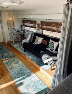 a living room with a black couch and a blue rug at Rustic Farm Stay in Temecula