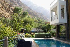 a house with a swimming pool and mountains in the background at La Perle de l'Ourika in Ourika