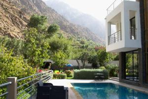 une maison avec une piscine et des montagnes en arrière-plan dans l'établissement La Perle de l'Ourika, à Ourika