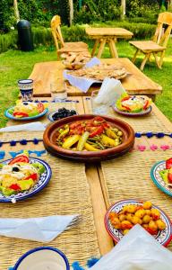 a wooden table with plates of food on it at La Perle de l'Ourika in Ourika