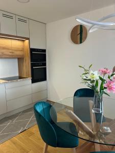 a kitchen with a glass table and two blue chairs at Downtown apartment Darinka in Poprad