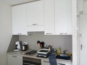 - une cuisine avec des placards blancs et un évier dans l'établissement Eliana Appartment, à Menton