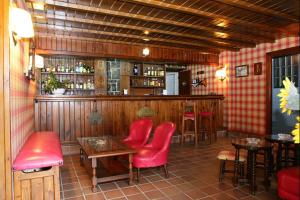 a restaurant with a bar with red chairs and tables at El Ancla in Laredo