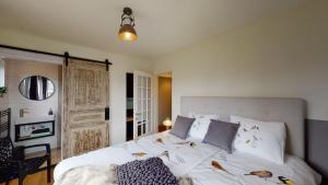 een slaapkamer met een groot bed met witte lakens en kussens bij Bauwerd12, met hottub in de voerstreek in Voeren