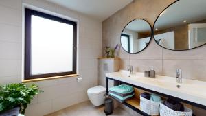 een badkamer met een wastafel en een spiegel bij Bauwerd12, met hottub in de voerstreek in Voeren