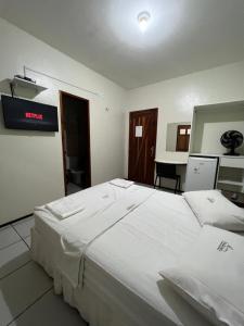 1 cama blanca grande en una habitación con escritorio en Hotel Pinheiro, en Ibiapina