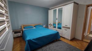 萨拉热窝SH Apartments Bistrik-Sarajevo的一间卧室配有蓝色的床和白色的橱柜