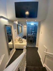 een kamer met een trap met een bank en een spiegel bij “ Nicky’s Retreat! Warm and quirky seaside flat! in Porthcawl