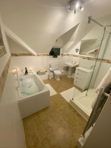 een grote badkamer met een bad en een douche bij “ Nicky’s Retreat! Warm and quirky seaside flat! in Porthcawl