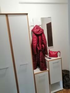 a red jacket sitting on a shelf next to a mirror at Dunja - Sajam in Novi Sad