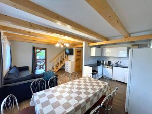 a kitchen and a living room with a table and chairs at Domek przy Gościńcu in Golczowice