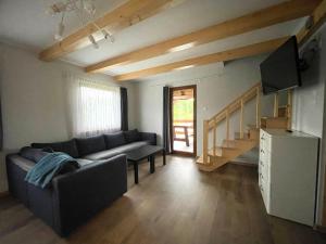 a living room with a couch and a staircase at Domek przy Gościńcu in Golczowice