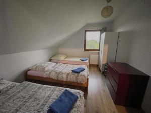 a bedroom with three beds and a dresser and a window at Domek przy Gościńcu in Golczowice +9 photos