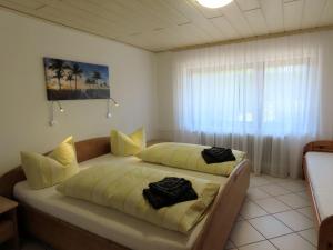 1 Schlafzimmer mit 2 Betten und einem großen Fenster in der Unterkunft Ferienwohnung Ossiander in Uhldingen-Mühlhofen