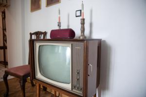 una vieja televisión con dos velas encima en Apartament Miedziana City Center, en Varsovia