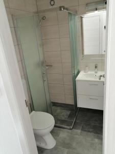 y baño con aseo y lavamanos. en Apartmani Grabovčić, en Punat